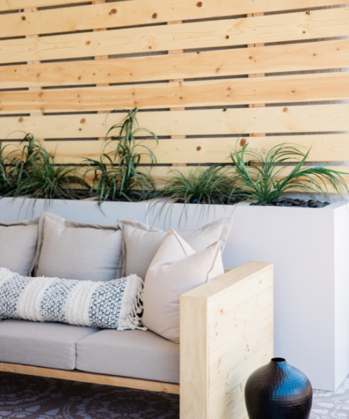 A couch sitting next to a planter filled with plants