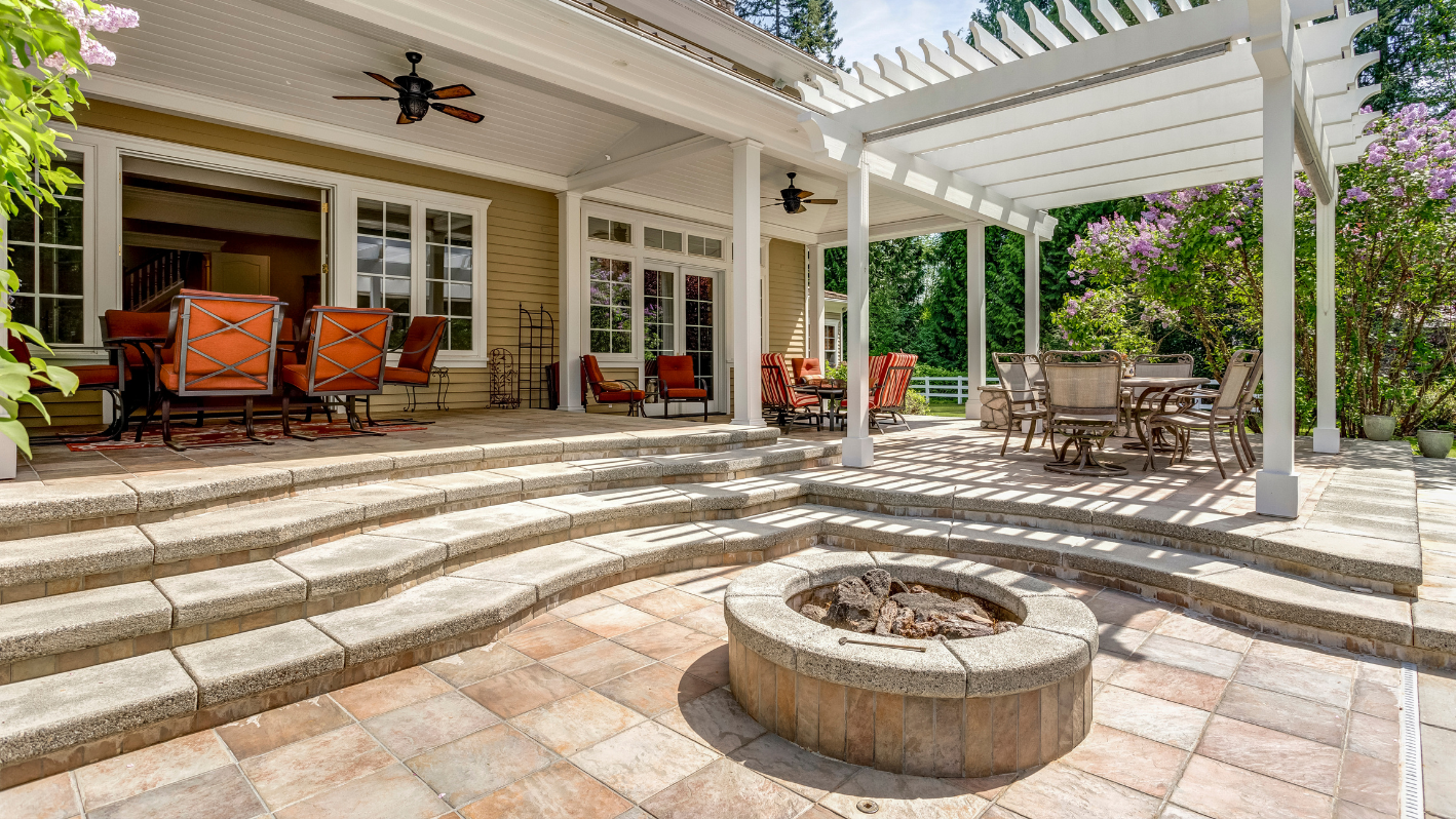 A patio with a fire pit and seating area