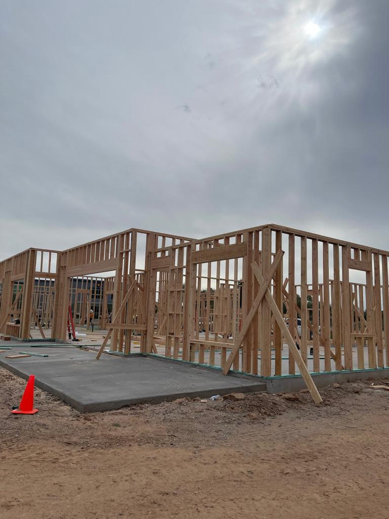 A house under construction with a red cone in the foreground